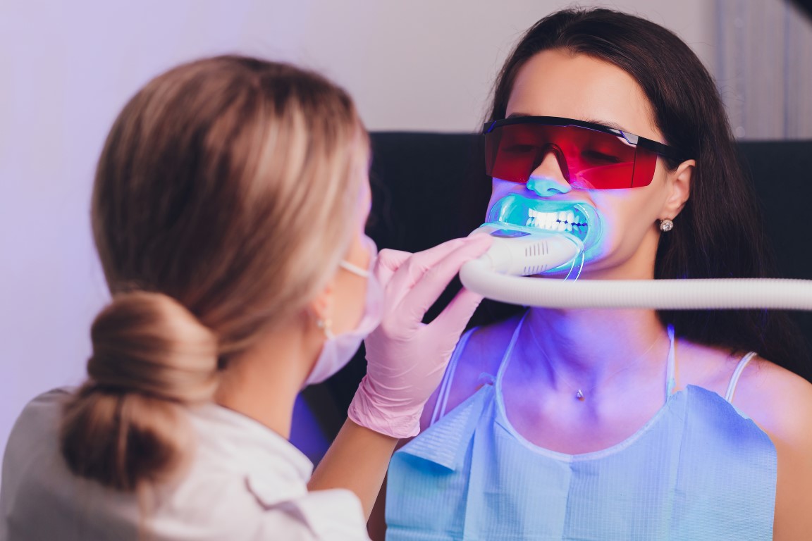 Close-up portrait of a female patient visiting dentist for teeth whitening in clinic,Teeth whitening procedure